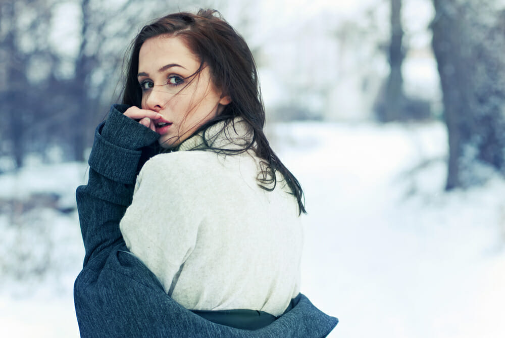 Girl in the snow glancing over her shoulder
